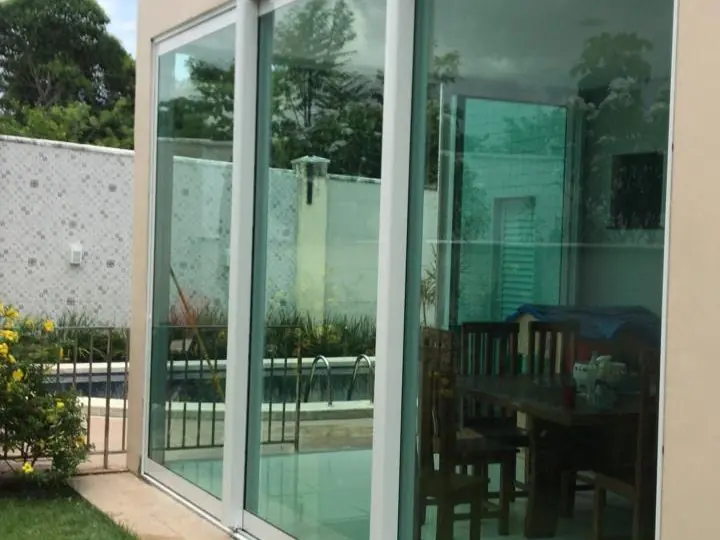 Porta de correr em vidro e alumínio, vista externa junto à piscina